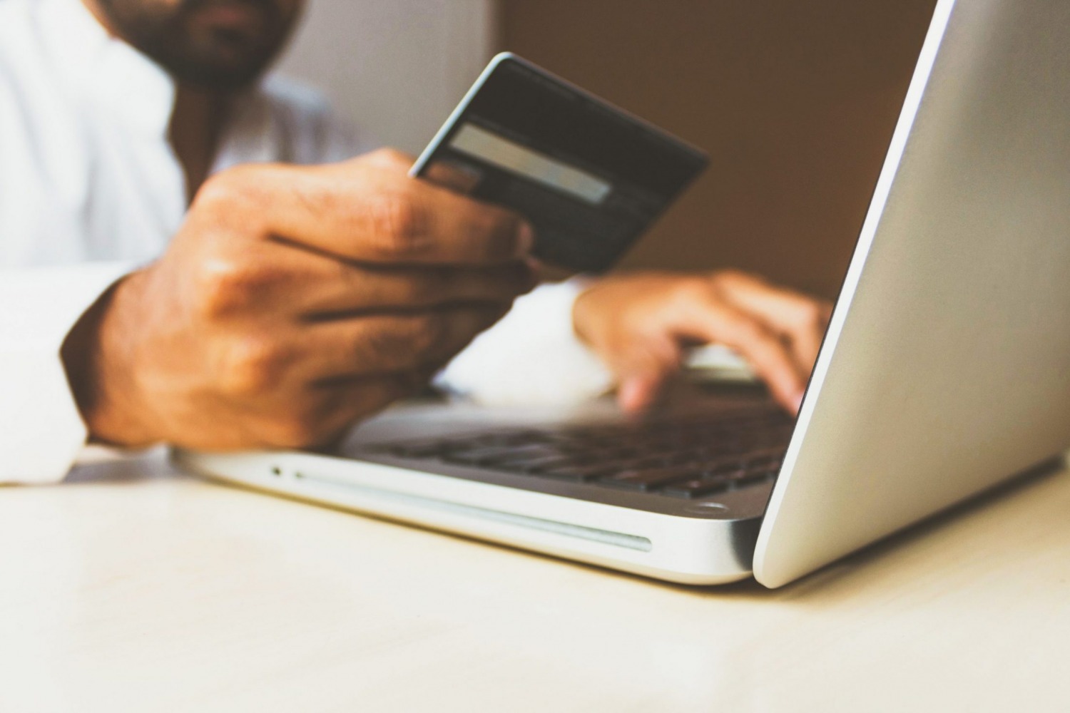 A man uses his credit card for an online purchase.